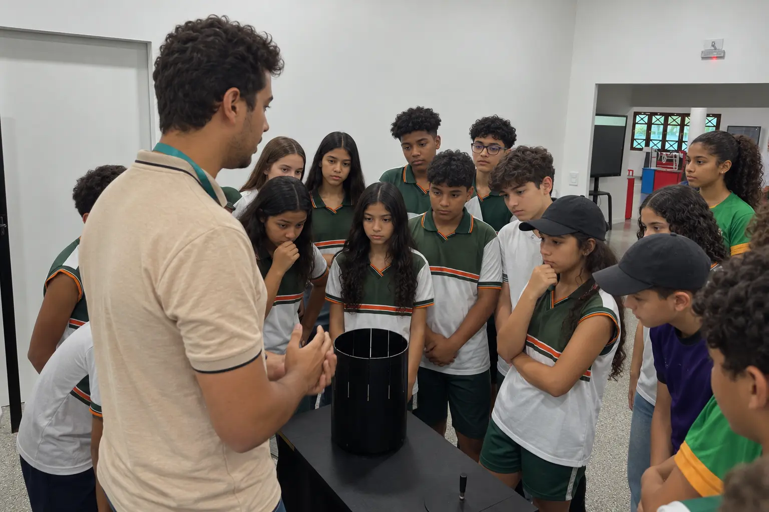 Alunos do 6º ao 9º ano do Colégio CEA, de farda verde, branca e laranja, acompanhando um experimento em visita de ciências